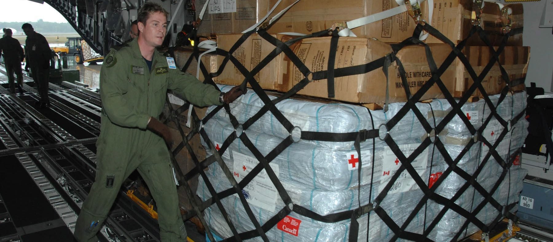 Canada Humanitarian Aid - man loading cargo on plane