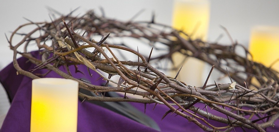 Crown of Thorns Laying on Purple Cloth with 3 candles around it