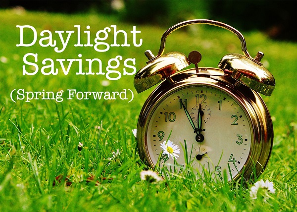 Alarm Clock on Grass with words Daylight Savings (Spring Forward)