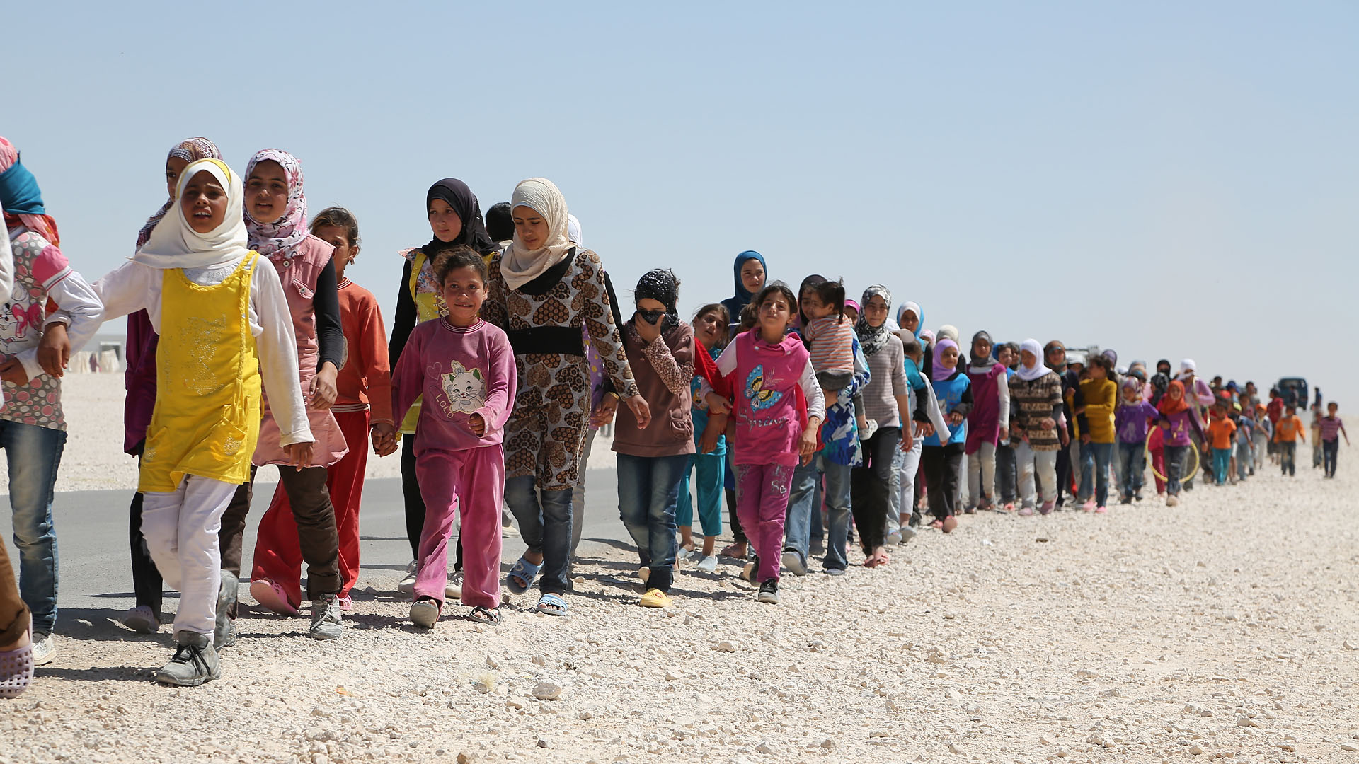 Line of Refugess walking on shoreline