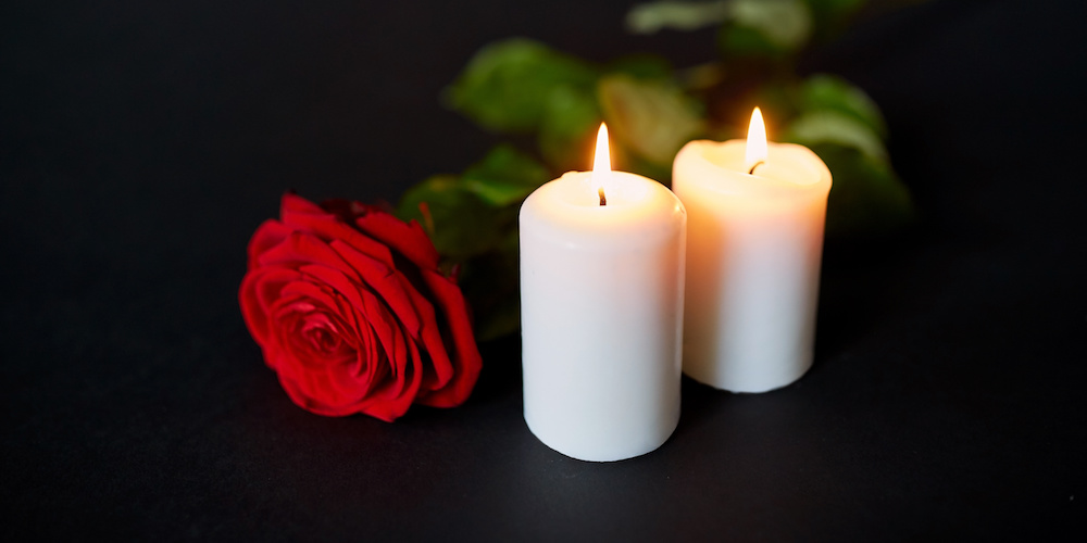 Two White Candles in front of  Red Rose