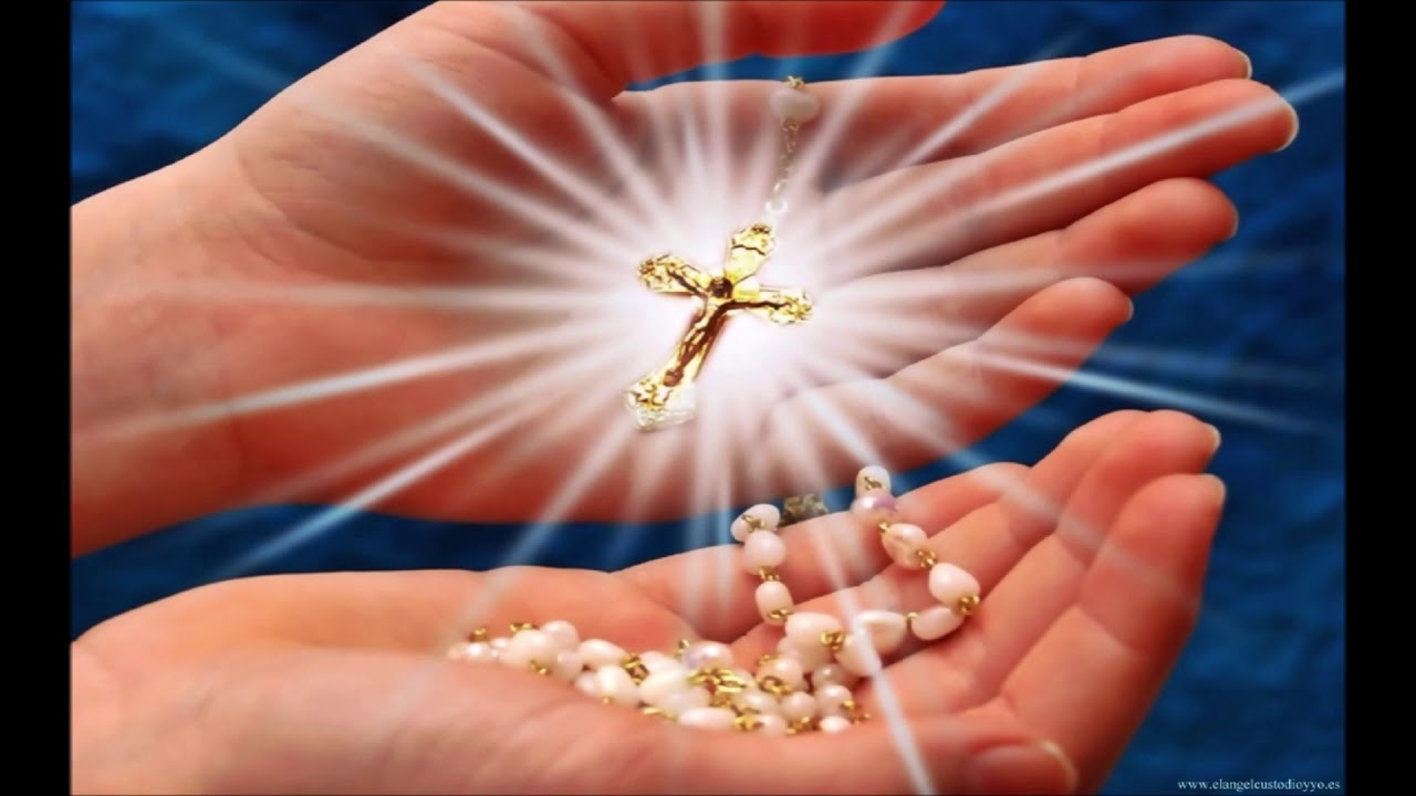 Hands Holding Rosary with Light Shining around Cross