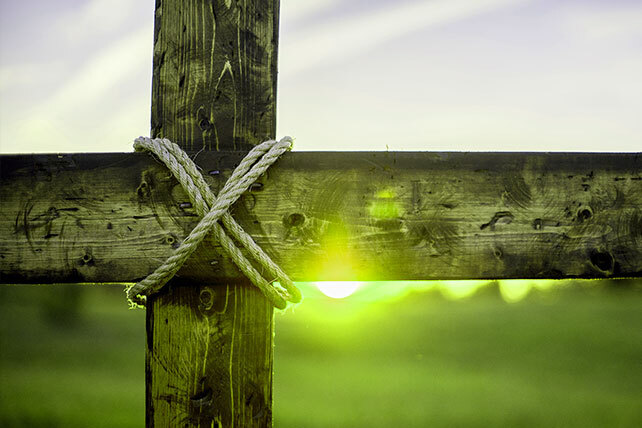 Cross with ropes at intersection with green background